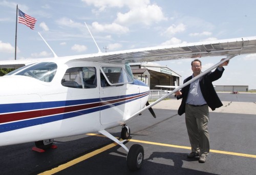 Ross McNutt by one of his aerial surveillance Cessnas